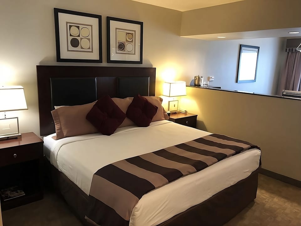 Unwind in a plush king bed with warm, calming light.