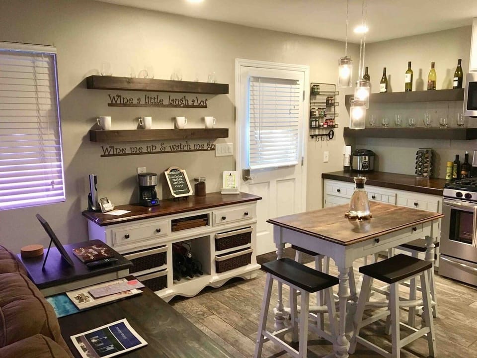 This delightful kitchen and dining area features a table perfect for two, complemented by a charming console for wine and coffee essentials. The stylish open shelving and modern appliances make this space both beautiful and fully functional for your stay.