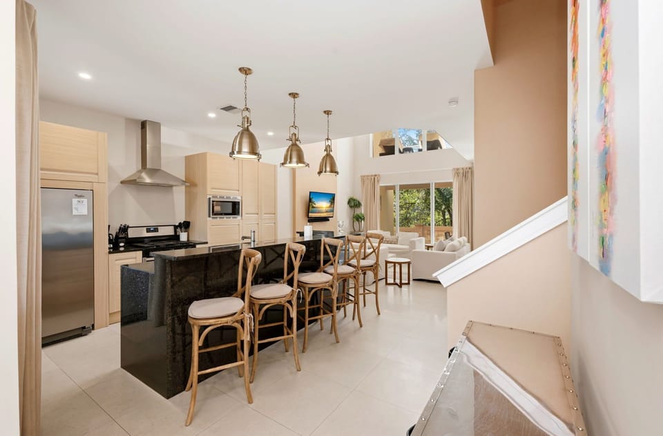 Modern kitchen with a large black granite island and seating for five.