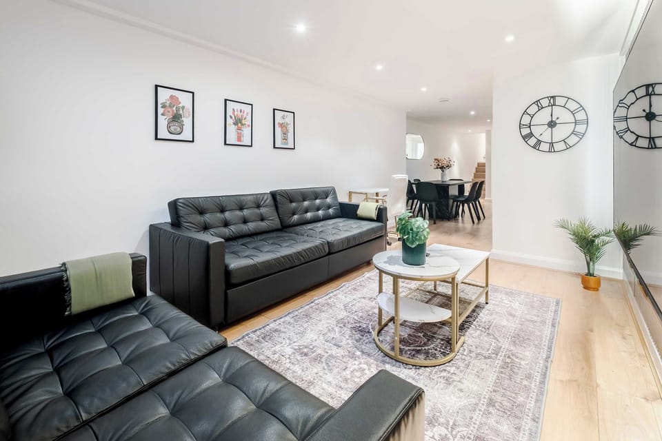 Living Room | Elevated luxury awaits in the living room, featuring a beautifully decorated space with a 70 inch smart TV, an open plan fully equipped kitchen, and a dining table seating up to 6 guests, perfect for sharing meals in comfort.