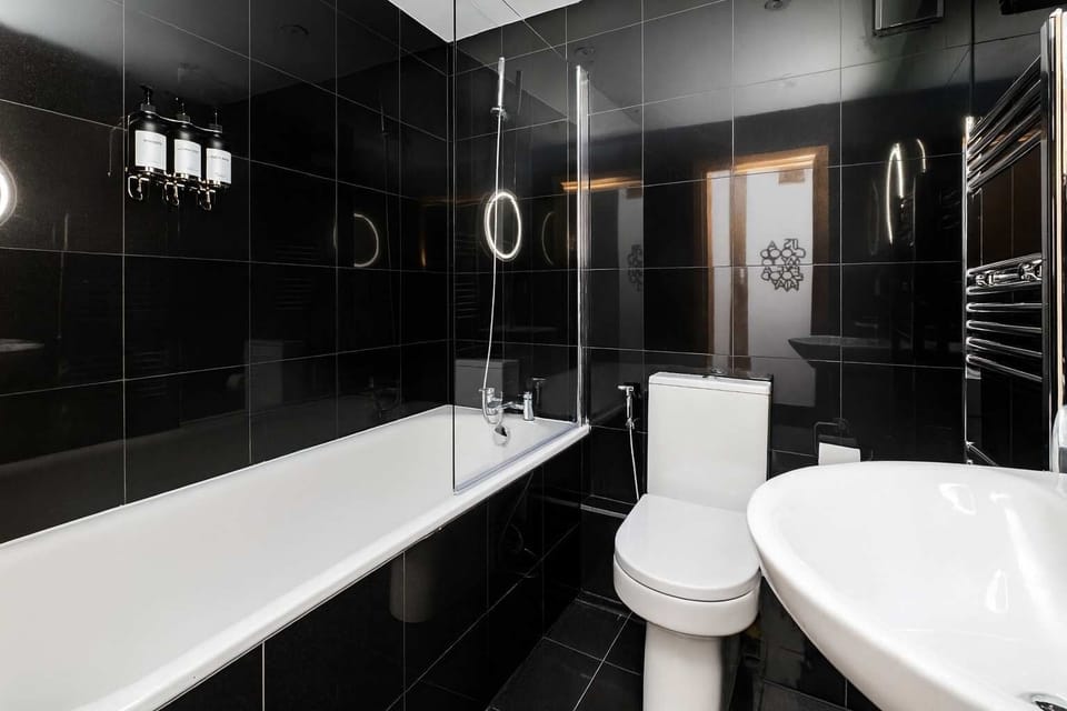 Full Bathroom 1 | The apartment boasts two modern bathrooms, one with a relaxing bathtub and the other with a walk in shower. Both toilets include a built in bidet function for added comfort and convenience.