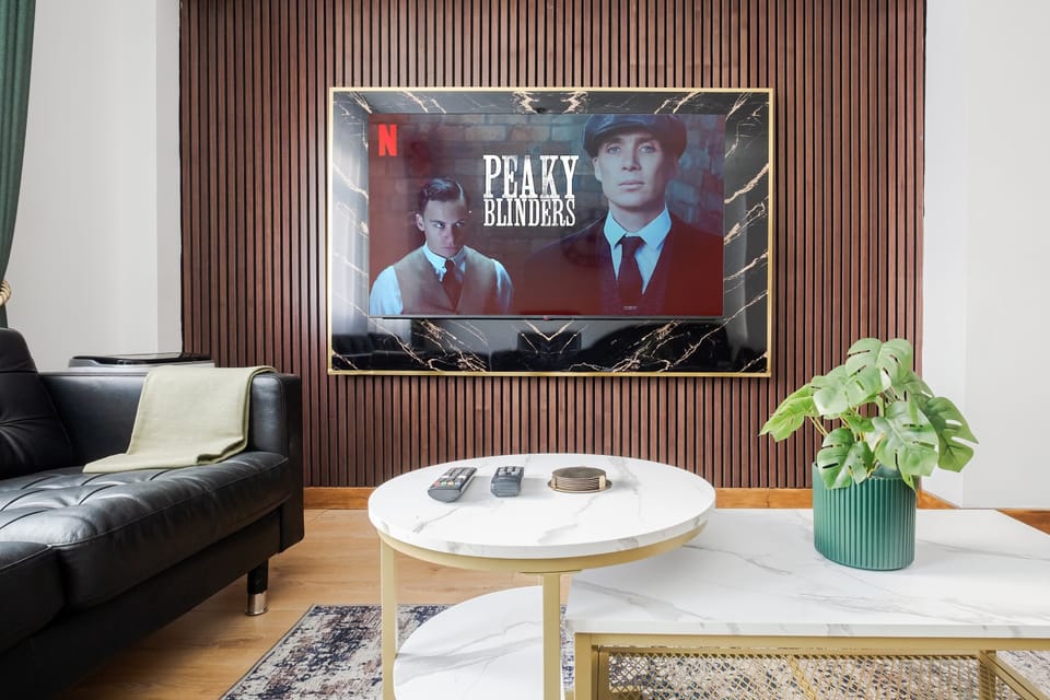 Living Room | Elevated luxury awaits in the living room, featuring a beautifully decorated space with a 70 inch smart TV, an open plan fully equipped kitchen, and a dining table seating up to 8 guests, perfect for sharing meals in comfort.