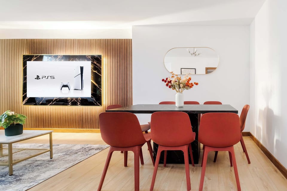 Living Room | Elevated luxury awaits in the living room, featuring a beautifully decorated space with a 75 inch smart TV, an open plan fully equipped kitchen, and a dining table seating up to 8 guests, perfect for sharing meals in comfort.
