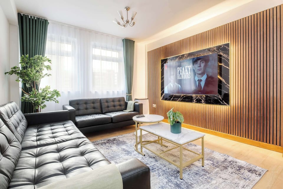 Living Room | Elevated luxury awaits in the living room, featuring a beautifully decorated space with a 75 inch smart TV, an open plan fully equipped kitchen, and a dining table seating up to 8 guests, perfect for sharing meals in comfort.