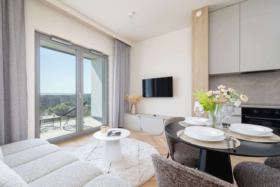 A small cozy seating area with a comfortable couch, coffee table, and large windows offering lots of daylight.
