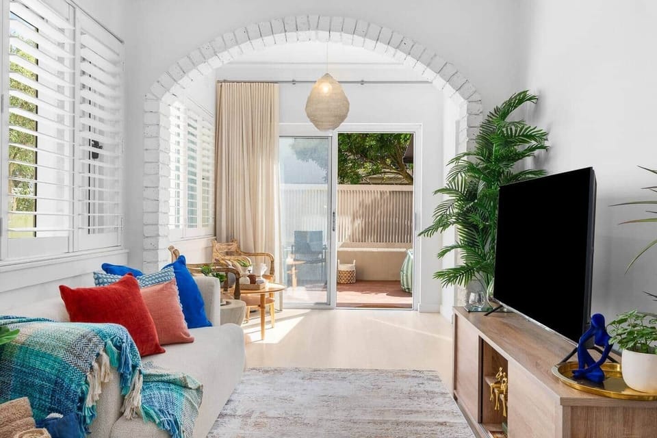 Smart tv with Netflix, disney+, Amazon prime etc
Living room with arched doorway and natural light in Bondi apartment