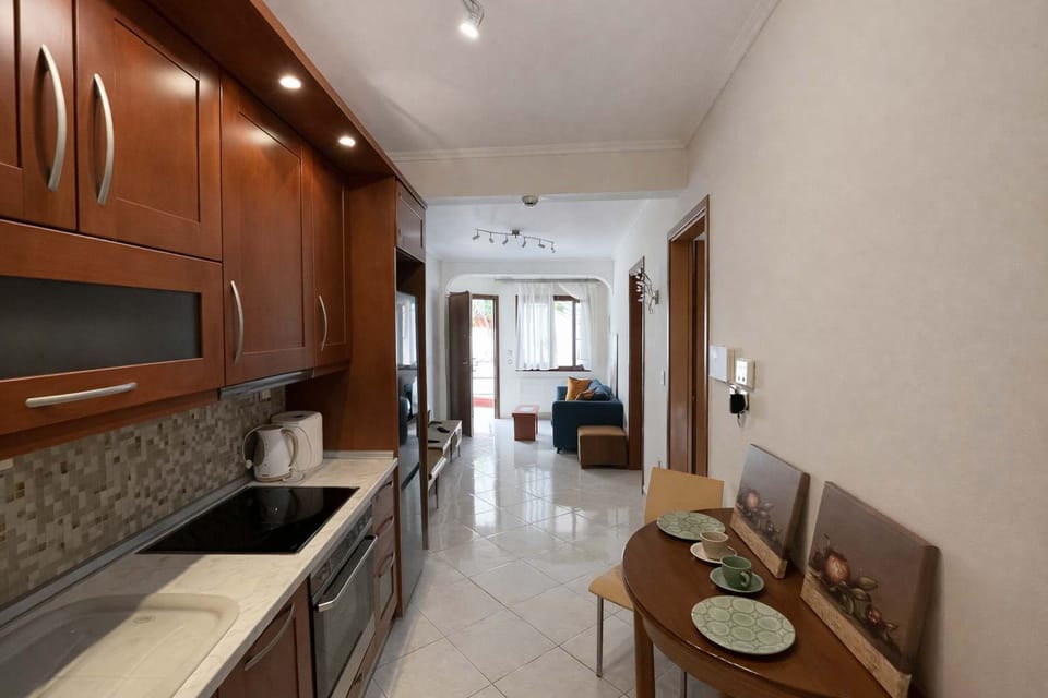 Fully Equipped Kitchen with Dining Nook
Compact kitchen with oven, stovetop, sink, and a small dining table for two.