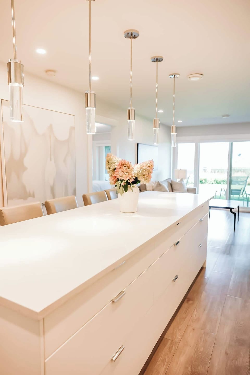 A bright, inviting kitchen and dining area, with a white countertop, breakfast bar, and outdoor views through a sliding door.



