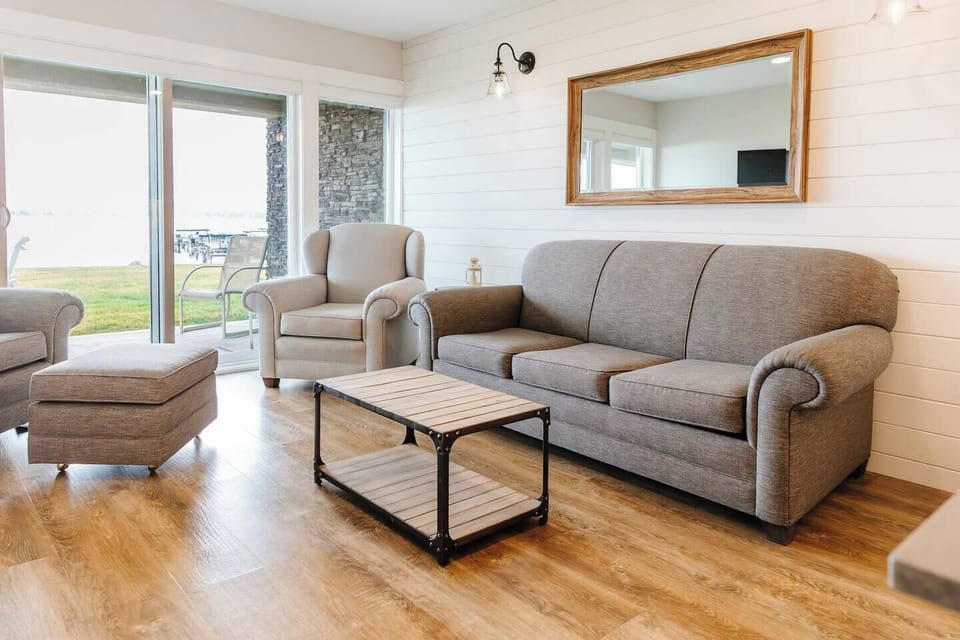 Living room with a grey sofa, coffee table, and TV mounted on the wall, creating a cozy spot to relax.