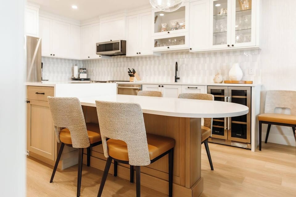 Modern kitchen with white cabinets, stainless steel appliances