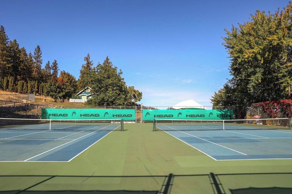 Two tennis courts, one with a net up, perfect for a game or practice