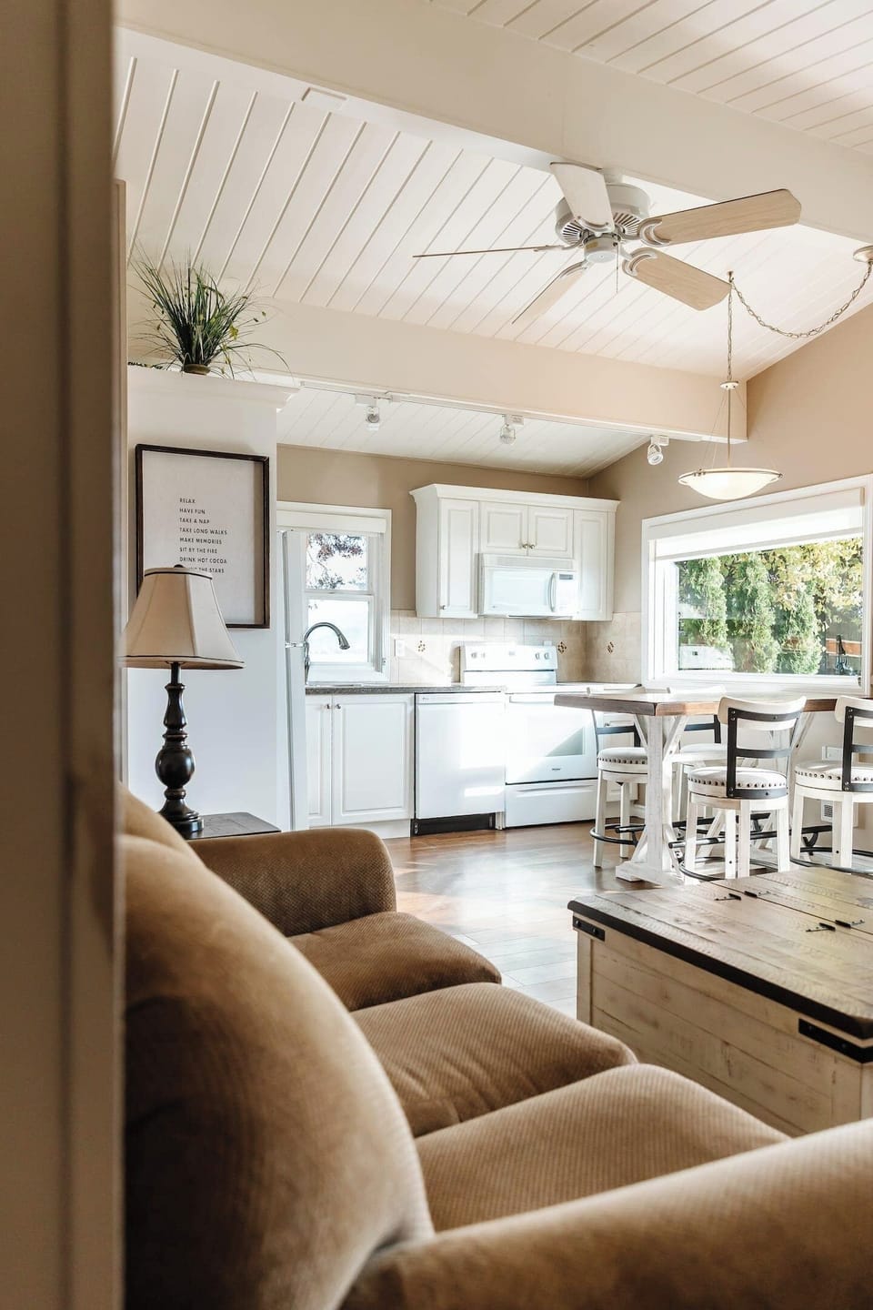 Comfortable living room with a couch, coffee table, and peaceful views of surrounding trees.