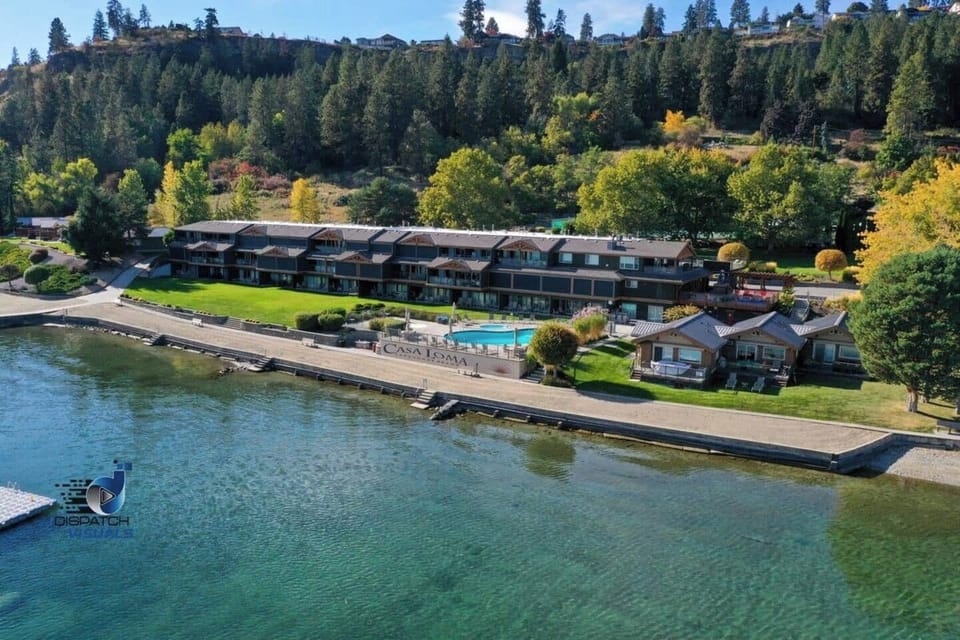 Aerial shot of a lakeside resort featuring a pool and charming buildings.