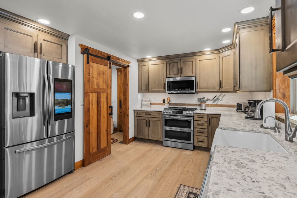 Your fully equipped gourmet kitchen features granite counters, stainless appliances, and rustic barn doors—perfect for creating memorable meals together.
