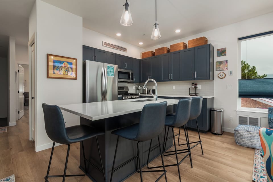 Your stylish kitchen features modern appliances, sleek countertops, and comfortable bar seating where you can enjoy morning coffee or evening meals together.