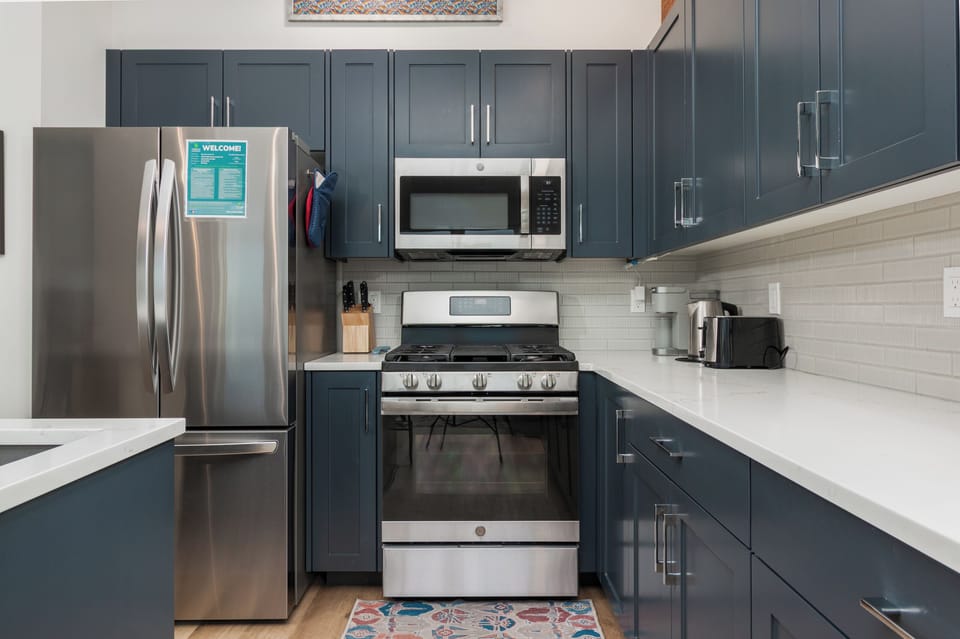 Your fully-equipped kitchen features sleek navy cabinets, stainless steel appliances, and everything you need to create memorable meals during your stay.