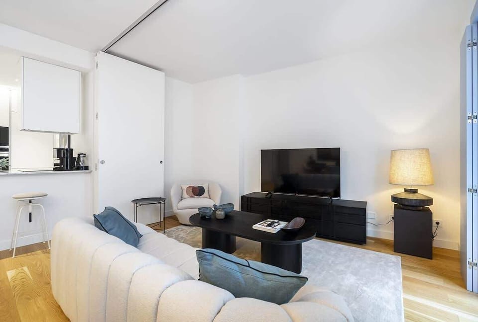 Spacious living room with a comfortable sofa, smart TV, and a design entertainment unit. A great natural light enhances the cozy, modern ambiance.