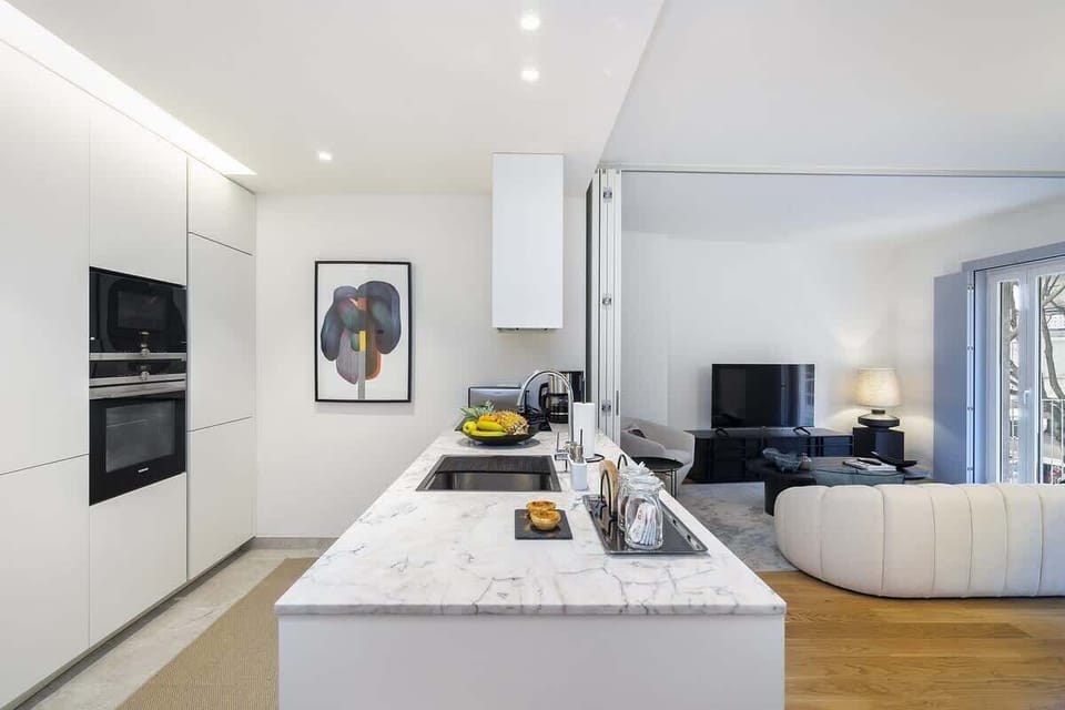 Modern open-plan kitchen connected to the living area. Features a marble countertop, built-in SIEMENES appliances. Bright and functional, perfect for cooking and entertaining mix. 