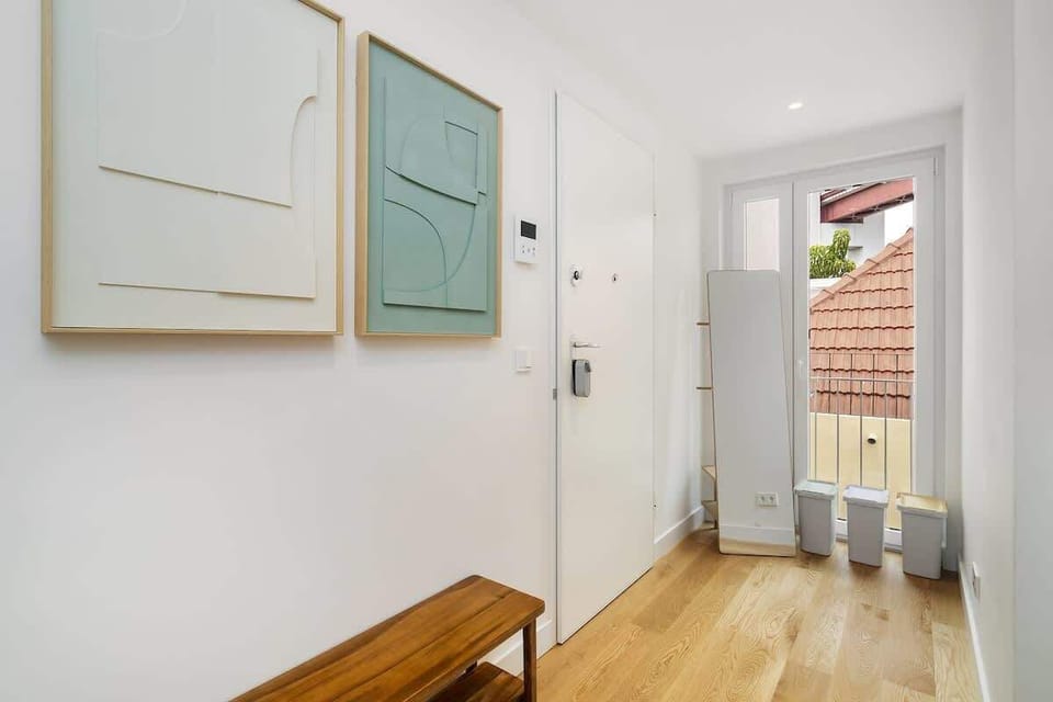 Spacious entrance of the apartment with long mirror and seating 