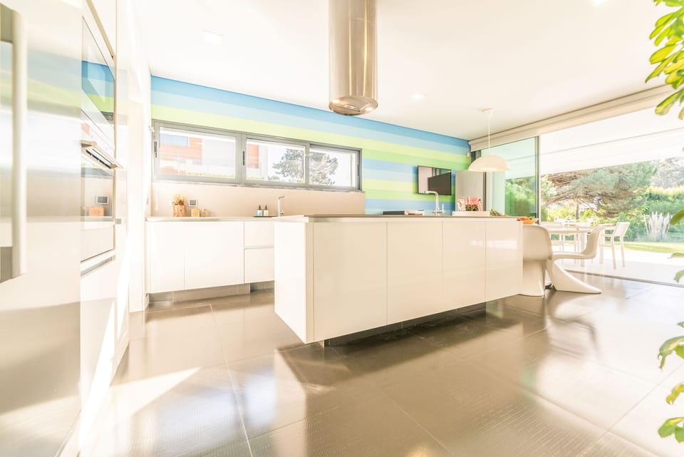 Bright open-plan kitchen with island and garden views — Villa Maria, luxury holiday villa in Herdade de Aroeira
