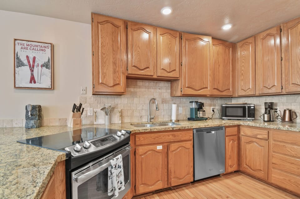 Your fully equipped kitchen invites home-cooked meals with granite counters, stainless appliances, and mountain-themed touches.
