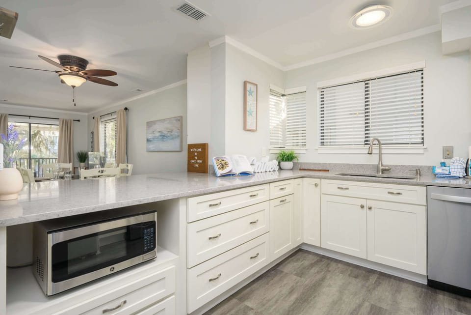 Bright, modern kitchen with white cabinetry and sleek stainless steel appliances.