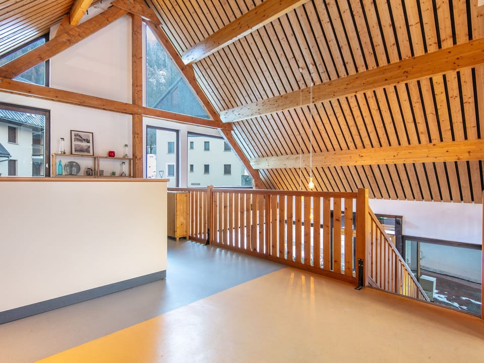 Inside, the spacious common area with its cozy wooden beams and ample natural light creates a warm, welcoming environment for families to gather.