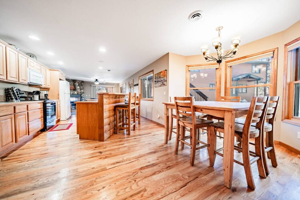 A spacious kitchen with bar seating and a dining table
