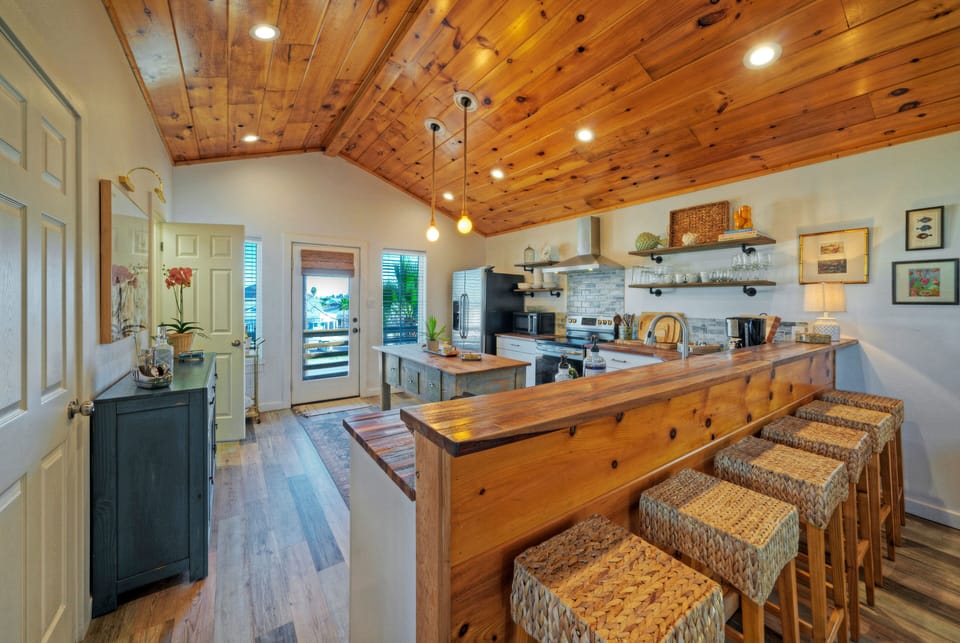 Bright, coastal-inspired kitchen with warm wood finishes—perfect for casual breakfasts, sunset cocktails, and gathering with friends.
