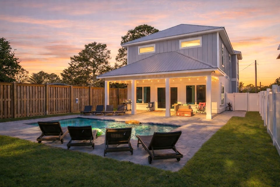 Modern two-story coastal home with a private pool and covered patio.