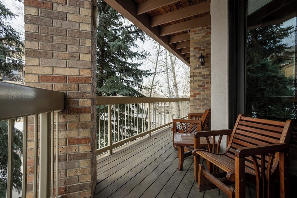Step onto your private balcony and settle into beautiful wooden furniture while enjoying peaceful tree-lined views.