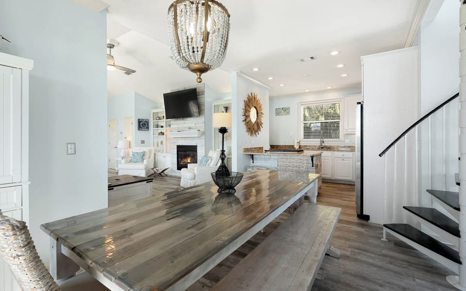 Gather around this stunning farmhouse dining table where memories are made beneath elegant crystal lighting.