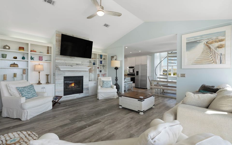 Unwind in your bright, open living space featuring a cozy fireplace, built-in shelving, and modern coastal touches that make you feel right at home.