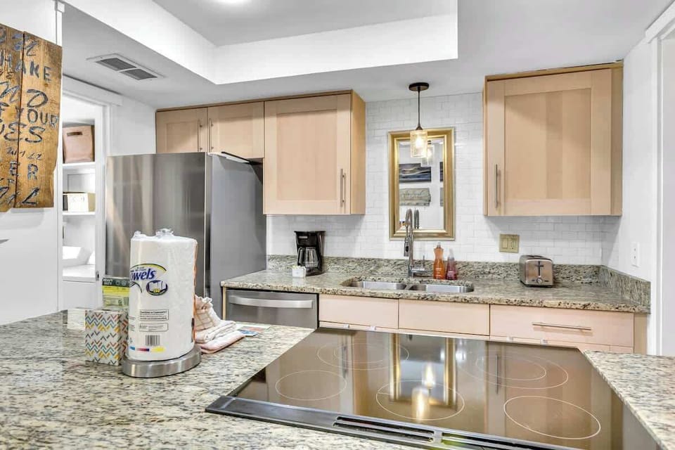 Your fully equipped kitchen invites culinary adventures with granite counters, stainless appliances, and warm wood cabinetry creating the perfect space for memorable meals.