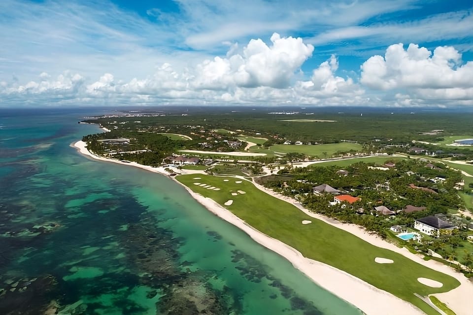 Cruise along endless shoreline where emerald fairways meet sea.