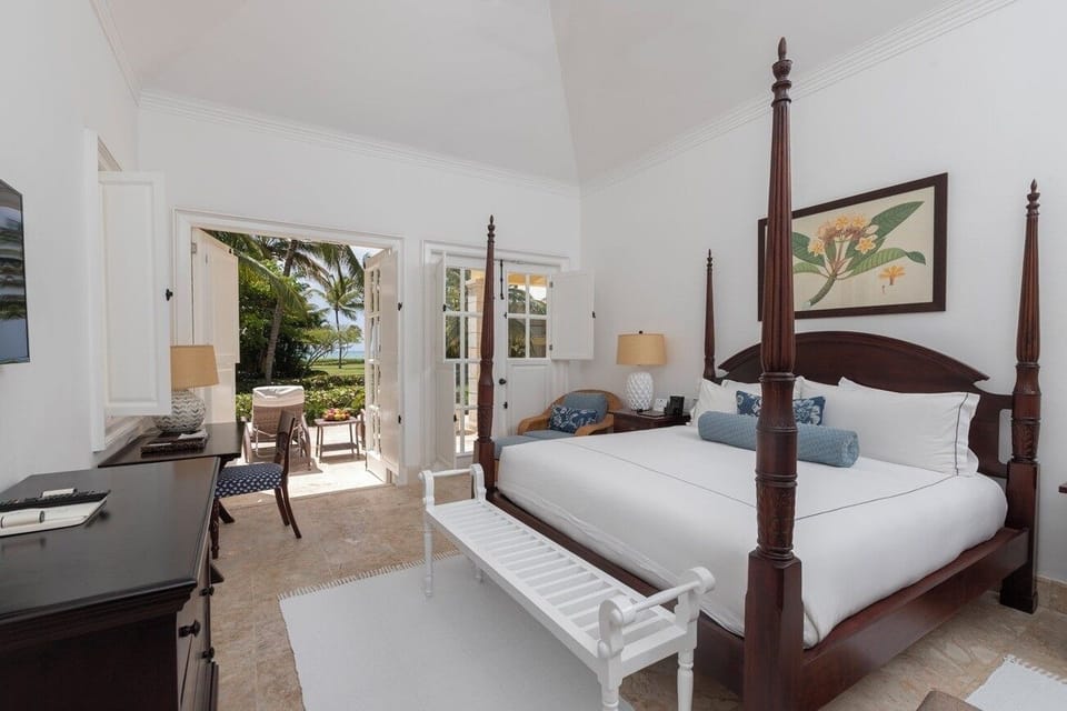 Unwind in crisp linens with garden-to-sea views outside.
