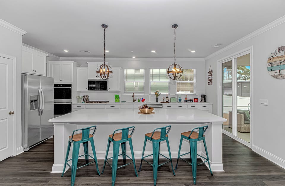 Kitchen: Bright and airy space with trendy barstools, perfect for breakfast gatherings!