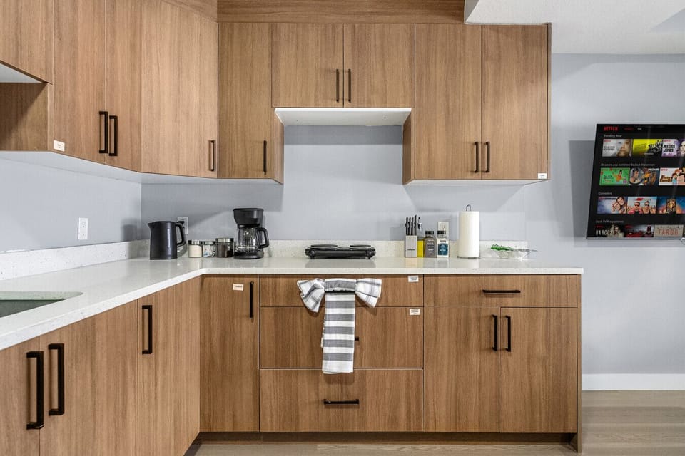 Fully equipped kitchen with coffee maker, hot plate, and ample storage
