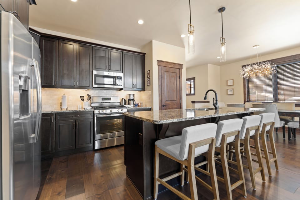 Gather around your spacious granite island with seating for six, where stainless appliances and dark wood cabinetry set the stage for memorable meals together.