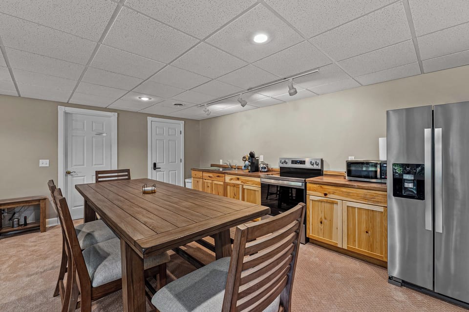 Lower-level kitchen and dining area – the home features TWO full kitchens including this downstairs kitchen with full appliances, perfect for large groups.