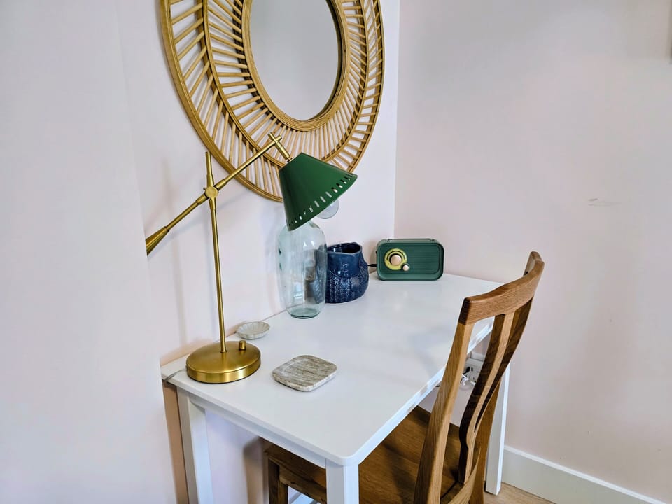 Your stylish workspace features a vintage radio, elegant gold mirror, and brass desk lamp for productive mornings.