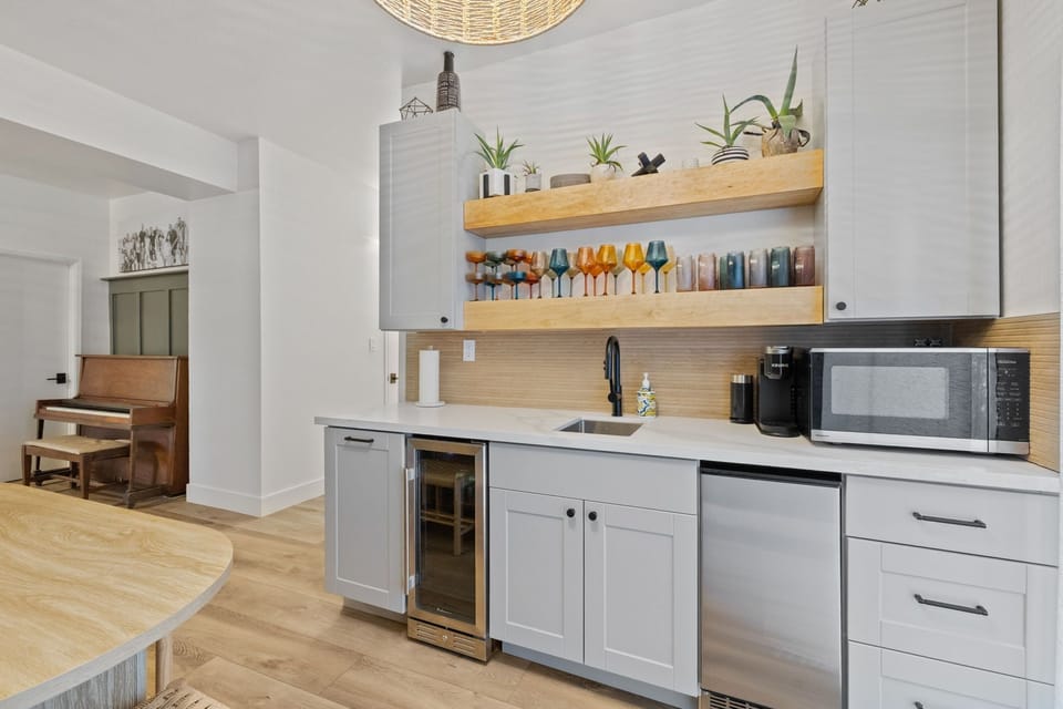 Downstairs kitchenette complete with sink, plastic drink-ware, microwave, mini fridge, ice maker and keurig. Also has a dining table that seats 6 and long bench seating with a plethora of games under it.