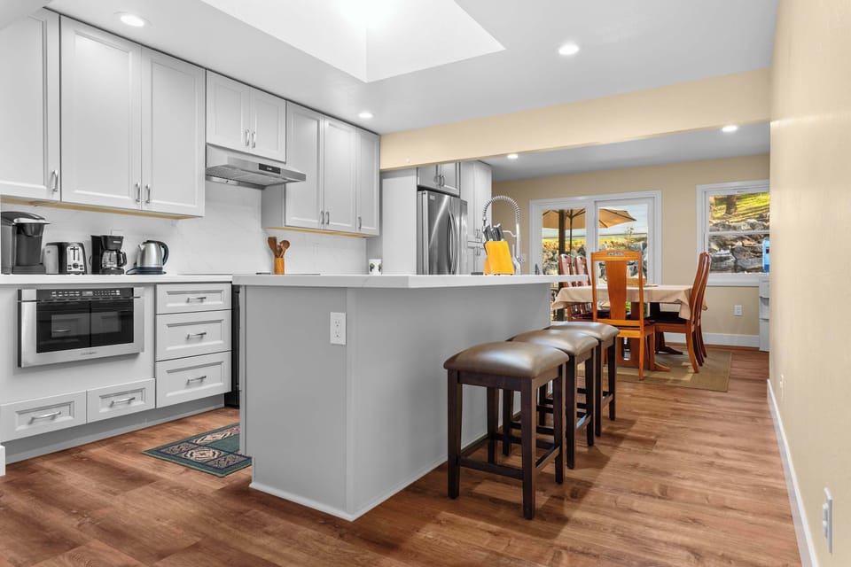 Fully equipped kitchen with induction stove, large refrigerator, and wine glasses—ideal for cooking in or storing your finds from Dry Creek Valley tasting rooms