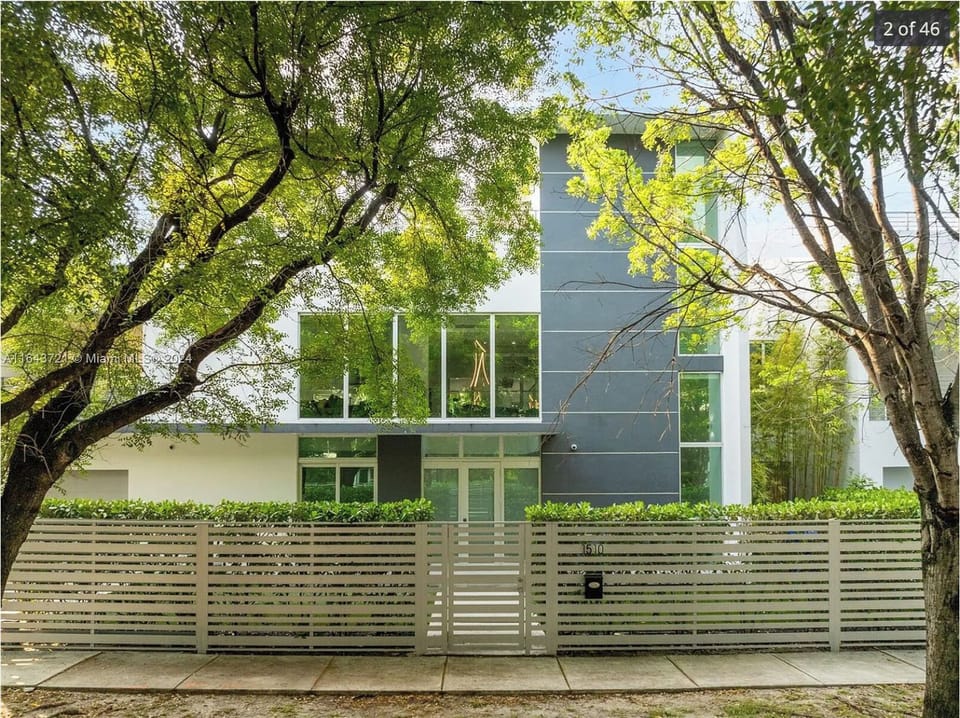 Modern home exterior surrounded by mature trees and lush landscaping