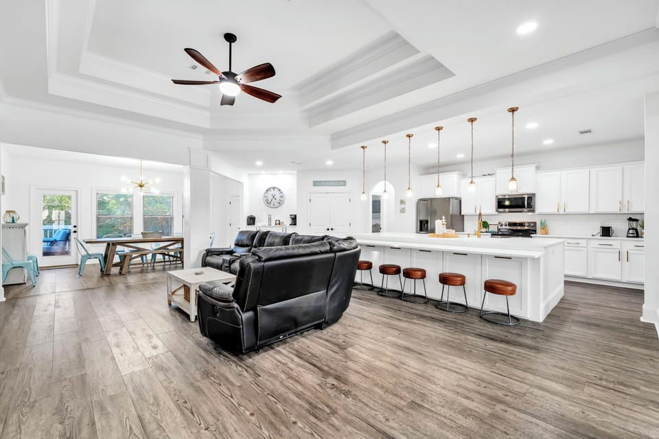 Relax in your spacious open-concept living area where comfort meets style with plush seating and a stunning kitchen island.