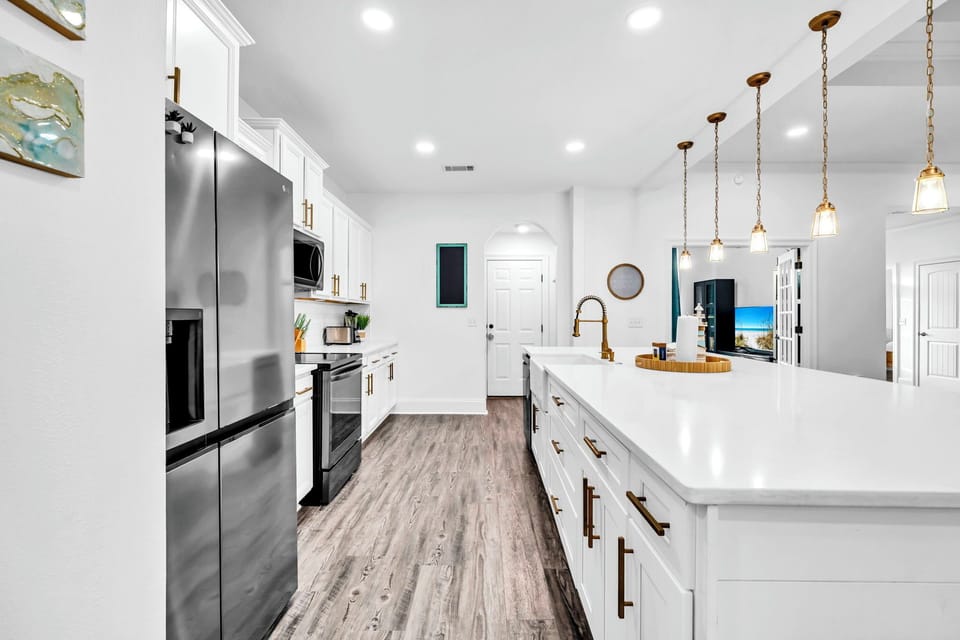 Your modern kitchen sparkles with white cabinets, granite counters, and pendant lights, perfectly equipped for memorable meals together.