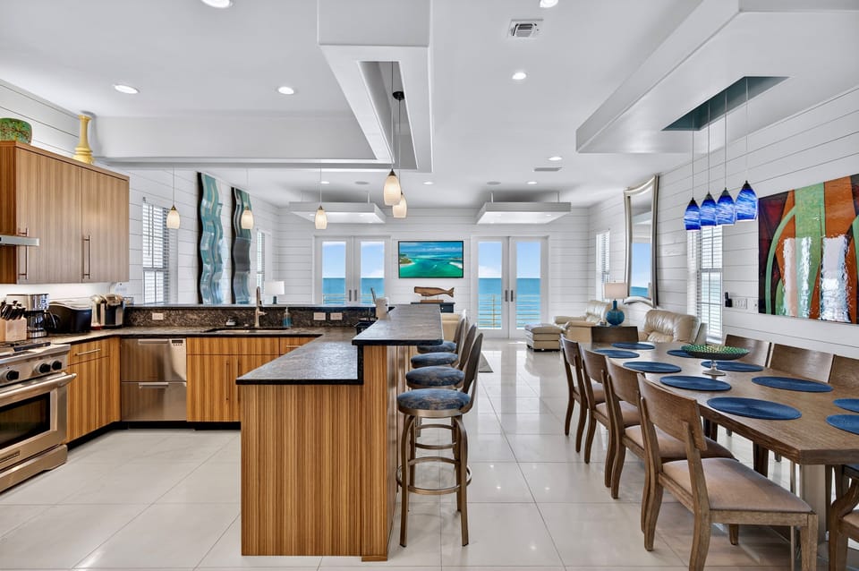 2nd Floor - Gourmet chef’s kitchen with professional gas range, stainless steel appliances, and expansive prep space—perfect for cooking meals together while enjoying stunning Gulf-front views and open-concept living.