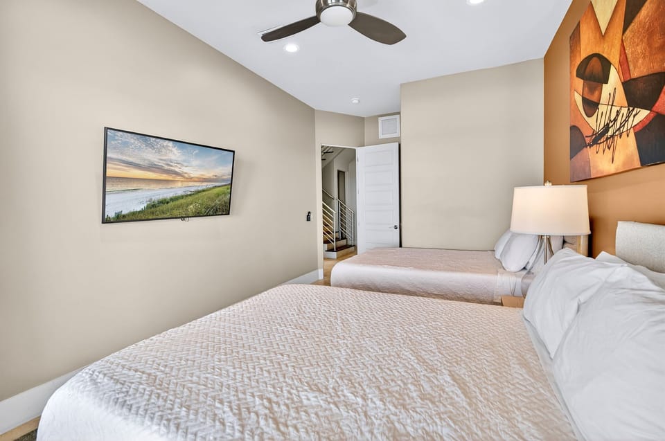 1st Floor - Gulf-front double queen bedroom with sweeping ocean views and direct pool deck access. This space shares a full bathroom with the adjacent King suite for added convenience.