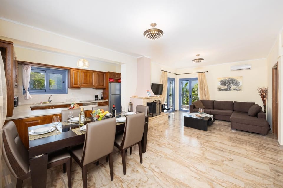 Open-plan living room with sofa, dining area, kitchen, ornamental fireplace, A/C, WiFi internet, and satellite TV