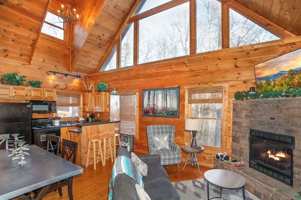 Open-concept living room with smart TV, electric fireplace, and a queen sleeper sofa